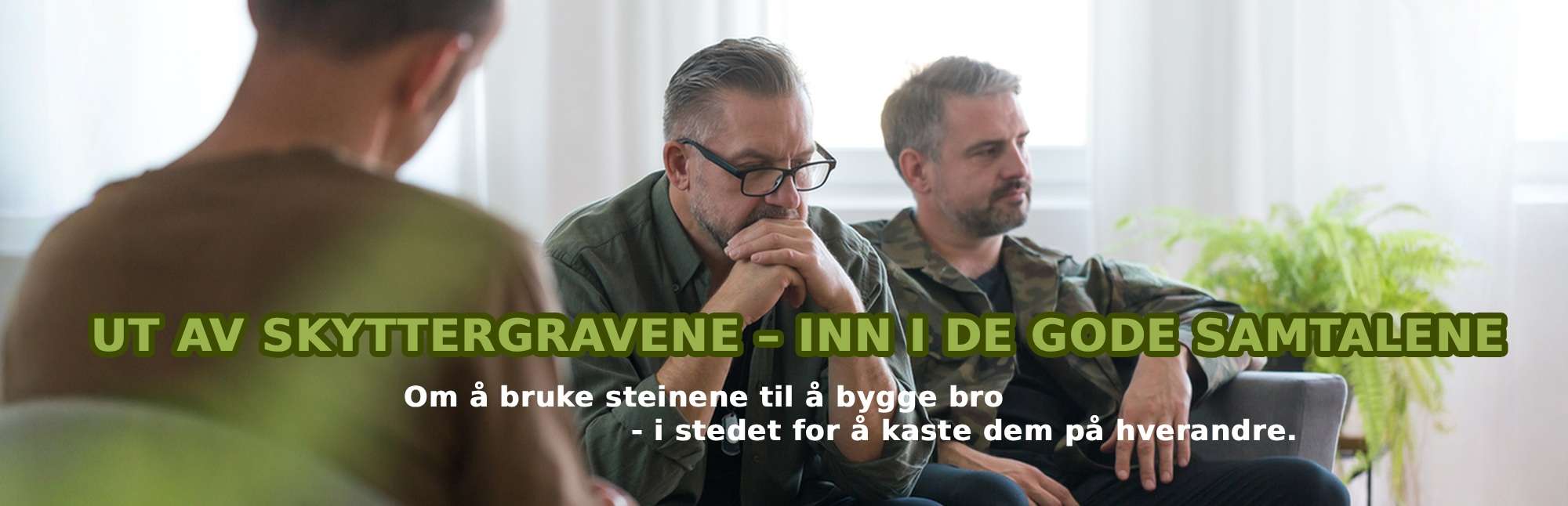 2 menn sitter i en sofa i samtale med en annen mann sittende på en stol